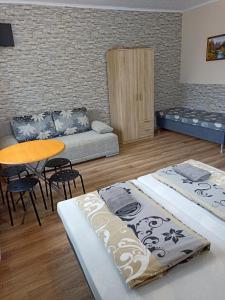 uma sala de estar com duas camas e uma mesa em Abturist penzion em Štúrovo