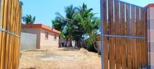 an open wooden gate in front of a house at Chambre D'hôtes Morondava in Morondava