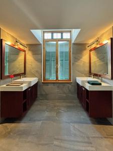 a bathroom with two sinks and two mirrors at PHA NYA RESIDENCE in Luang Prabang