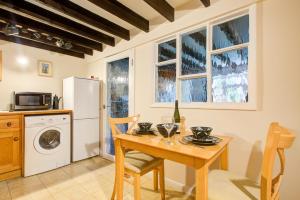 a kitchen with a wooden table and a refrigerator at Charming Hilltop Cottage with Panoramic Views in East Worldham