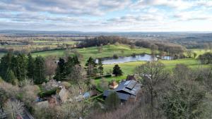 einem Luftblick auf ein Haus und einen See in der Unterkunft Charming Hilltop Cottage with Panoramic Views in East Worldham