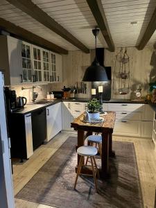cocina con armarios blancos y mesa de madera en Koselig enmannsom i tømmerhus, inkl morgenkaffe en Eidsvoll