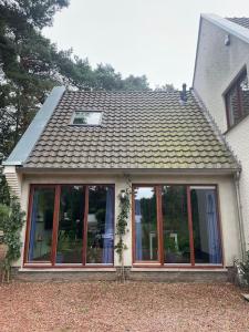 uma casa com um telhado com janelas em Vier sterren woning met bubbelbad bij bos en meer em Maasmechelen