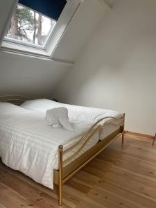um quarto com uma cama com lençóis brancos e uma janela em Vier sterren woning met bubbelbad bij bos en meer em Maasmechelen