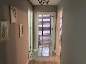 a hallway with a door leading to a room with shutters at Adana Centrum Flat 1 in Seyhan