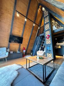 a living room with a table and a staircase at Loon Moon Mountain Chalets in Sarajevo
