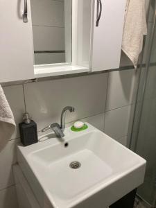 lavabo blanco en el baño con espejo en Adana Centrum Flat 1, en Seyhan