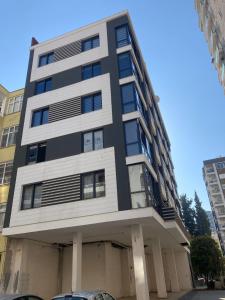 a black and white building with a car parked in front at Adana Centrum Flat 1 in Seyhan