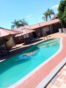 a swimming pool in front of a house at Mokopane at Freedom City Lodge in Mokopane