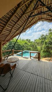 a wooden deck with a table and chairs on it at Glamping Wilpattu by Thamaravila in Wilpattu