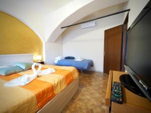 ein Hotelzimmer mit 2 Betten und einem Flachbild-TV in der Unterkunft DIMORA DEL MOLO 1 ACQUARIO - GENOVABNB it in Genua