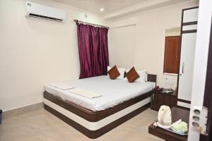 ein Schlafzimmer mit einem Bett mit einem roten Vorhang in der Unterkunft HOTEL GITANJALI in Māldah