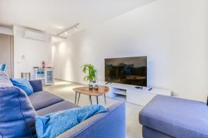 a living room with a blue couch and a tv at Stylish & Cosy 1BR home with Balcony in St Julians BY 360 Estates in Tal-Għoqod