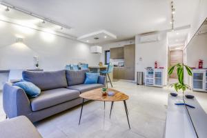 a living room with a couch and a table at Stylish & Cosy 1BR home with Balcony in St Julians BY 360 Estates in Tal-Għoqod