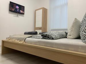 een bed in een kamer met een tv aan de muur bij Tiny Apartments in Miskolc