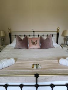 una cama con almohadas y una mariposa en ella en The Old Rectory, en Sedgeberrow