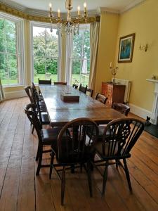 comedor con mesa de madera y sillas en The Old Rectory, en Sedgeberrow