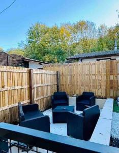 eine Terrasse mit Stühlen, einem Tisch und einem Zaun in der Unterkunft Bel appartement avec Jacuzzi #1 in Bourgoin