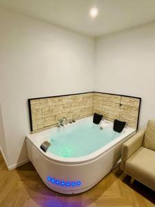 eine große Badewanne in einem Zimmer mit Sofa in der Unterkunft Bel appartement avec Jacuzzi #1 in Bourgoin