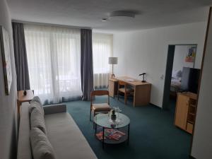 a living room with a couch and a table at Hotel Bessunger Forst in Roßdorf