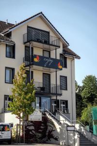ein großes weißes Gebäude mit einem Schild drauf in der Unterkunft Hotel Enjoy in Goldach