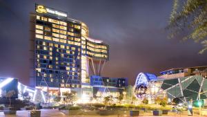 a tall building at night with a roller coaster at Pretoria East Guests in Pretoria