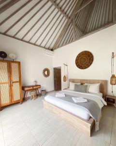 a bedroom with a large bed and a table at Mimpi Villa - Gili Air in Gili Air