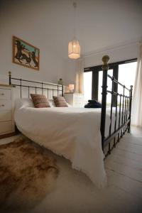 a bedroom with a large bed with white sheets and pillows at Little Well, stunning setting - 2 acres, dogs welcome in Slapton
