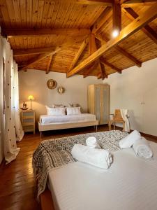 1 dormitorio con 2 camas en una habitación con techos de madera en Homey Stoupa, Mani, en Stoupa
