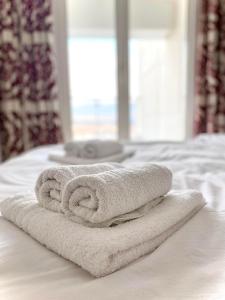 uma pilha de toalhas sentadas em cima de uma cama em Skopje Sky Apartment 32nd floor em Skopje