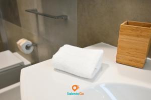 un asciugamano bianco seduto sopra un bancone del bagno di Stanze VILLA DEL CONTE a Punta Prosciutto by SalentoGo a Punta Prosciutto