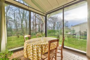 eine abgeschirmte Veranda mit einem Tisch und Stühlen in der Unterkunft Lanton - 700m plage - Extérieur et charme in Cassy + 20 Fotos