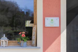 un cartello su una finestra con una pianta su un davanzale di Agriturismo Torsivì a Castiglione Chiavarese
