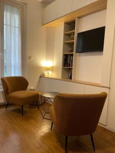 un salon avec deux chaises et une table et une télévision dans l'établissement Studio Paris tour Eiffel, à Paris