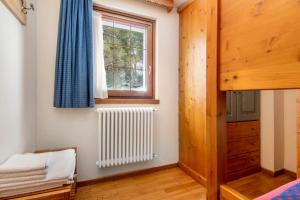 a bedroom with a radiator and a window at Residence Larice Bianco App n3 in Campodolcino