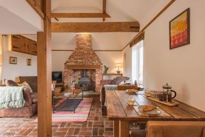 ein Wohnzimmer mit einem Tisch und einem Kamin in der Unterkunft Little Ripple Cottage by Bloom Stays in Canterbury