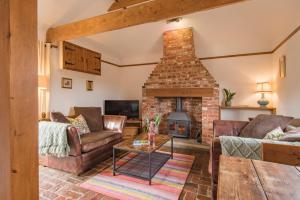 a living room with two couches and a brick fireplace at Little Ripple Cottage by Bloom Stays in Canterbury