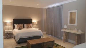 a bedroom with a large bed and a table at K Partners' Boutique Hotel & Spa in Langebaan