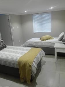 2 nebeneinander sitzende Betten in einem Schlafzimmer in der Unterkunft K Partners' Boutique Hotel & Spa in Langebaan