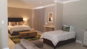 a hotel room with two beds and a chair at K Partners' Boutique Hotel & Spa in Langebaan