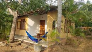 a blue hammock in front of a house at Aloe Vera Garden in Tangalle