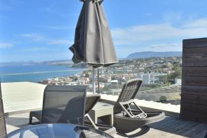 a patio with an umbrella and chairs and a table at Galini Sea View in Agia Marina Nea Kydonias