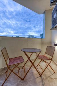 two chairs and a table on a balcony at Stylish & Cosy 1BR home with Balcony in St Julians BY 360 Estates in Tal-Għoqod