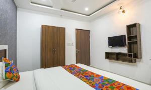 a bedroom with a bed and a flat screen tv at VINAYAK GUESTHOUSE in Lucknow
