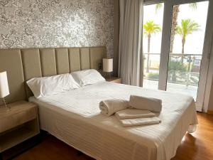 Apartamentos las Palmas VII Family only في سالو: غرفة نوم عليها سرير وفوط