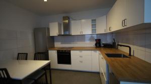 a kitchen with white cabinets and a wooden counter top at Ferienwohnung Best Apartments Leverkusen 2 in Leverkusen