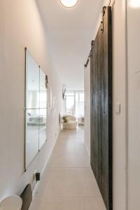 pasillo con paredes blancas y puerta de madera en Modern studio near the beach, en Ostende