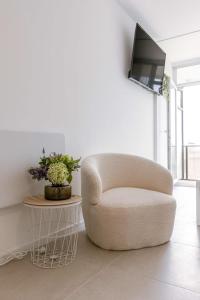 Sala de estar blanca con silla y mesa en Modern studio near the beach, en Ostende