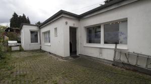 a white house with a door and a window at Ferienwohnung Best Apartments Leverkusen 2 in Leverkusen