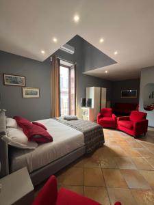 a bedroom with a large bed and two red chairs at Naples Luxury Suites B&B in Naples +19 photos